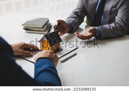 Real estate agent is discussing and explaining the terms of the home purchase contract. Businessman signing a contract agreement, mortgage, rent, lease, home insurance.