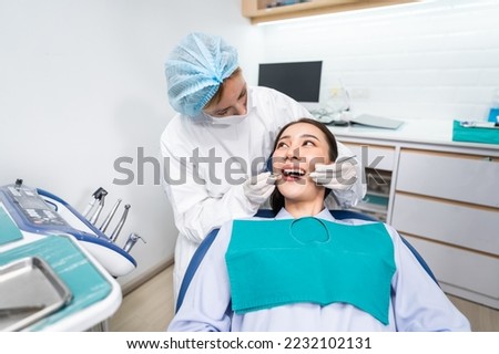 Caucasian dentist examine tooth for young girl at dental health clinic. Attractive woman patient lying on dental chair get dental treatment from doctor during procedure appointment service in hospital Royalty-Free Stock Photo #2232102131