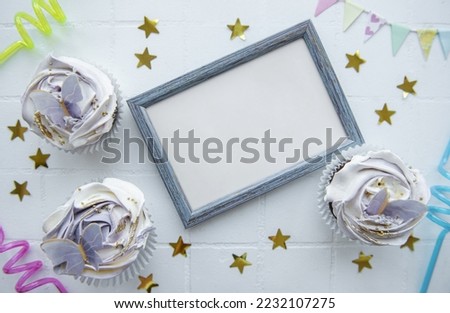 Birthday holiday cupcakes with butterfly decorations and picture frame - holiday background