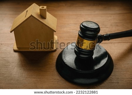 Concept of real estate auction, legal system and property division after divorce. Gavel and house toys on a wooden background. Royalty-Free Stock Photo #2232122881