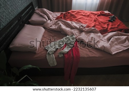 Cluttered bedroom with piles of clothes. An unmade bed in the early morning when its still dark Royalty-Free Stock Photo #2232135607