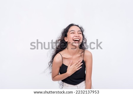 An exuberant and lively young woman laughing. A happy and lighthearted scene. Isolated on a white backdrop. Royalty-Free Stock Photo #2232137953