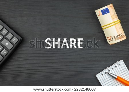 SHARE - word (text) and euro money on a wooden background, calculator, pen and notepad. Business concept (copy space).