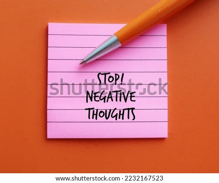 Pink note on orange background with pen written STOP NEGATIVE THOUGHTS, means stop mind fro attracting negative life experiences, overcome and remove negative thinking  Royalty-Free Stock Photo #2232167523