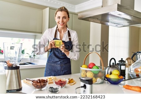 Young blonde woman make photo tu banana slices at kitchen