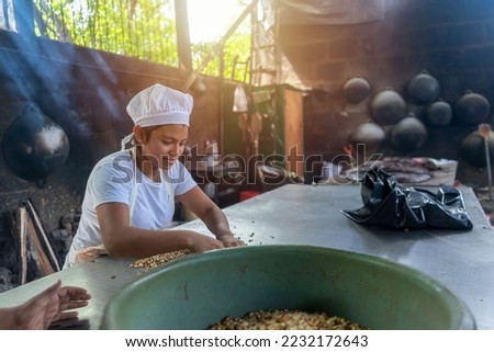 Young latin woman working in a traditional kitchen in Masaya Nicaragua Royalty-Free Stock Photo #2232172643