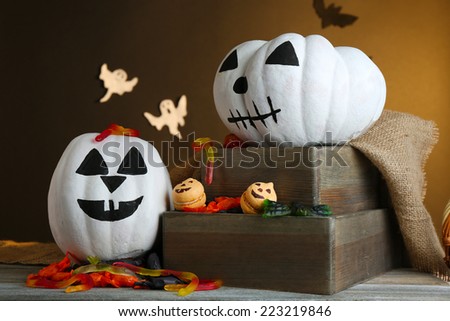 White Halloween pumpkins on wooden table on dark color background