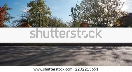 Long blank commercial signboard with white space for mockup mounted on hoarding at city street Royalty-Free Stock Photo #2232213651