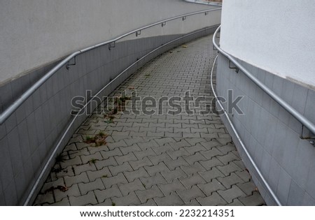 railing with two handrails. made of galvanized steel prisms. the lower railing is a protection against wheelchairs. ramp for the immobile in the housing estate, stainless steel, staircase, ramp