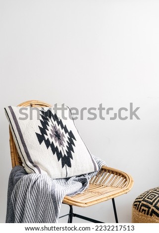 Close up view of white cushion at rattan chair. Bohemian living room with cozy furnishing. Wooden vintage armchair with design element at oriental or asian decorative pillow against copy space wall
