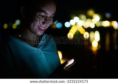 night portrait with bokeh, Female night portrait playing smartphone