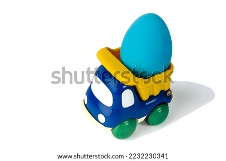  A toy children's dump truck transports an Easter gift egg