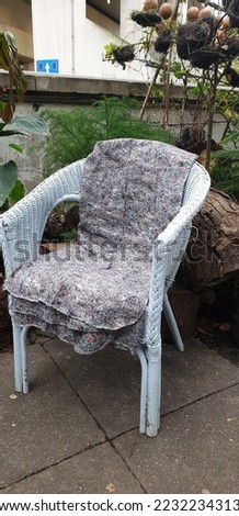 Outdoor empty wicker chair with blanket