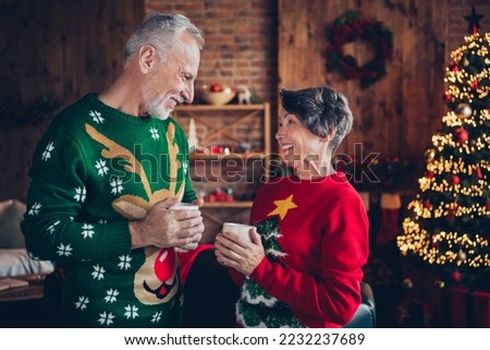 Photo of two peaceful aged people hands hold hot tea mug speak communicate enjoy newyear atmosphere house indoors
