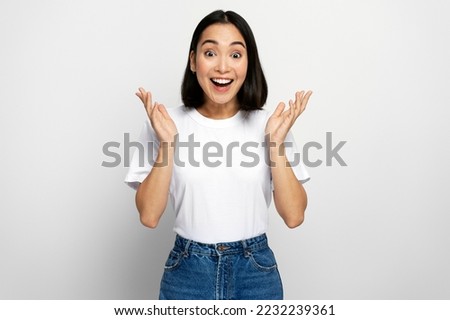 Happy surprised woman looking at camera with mouth open in amazement, expressing shock, astonishment. indoor studio shot, white background  Royalty-Free Stock Photo #2232239361
