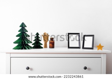 Christmas mock up with black frame and Honeycomb tree paper decor. Square frame on a wooden shelf against a white wall. Copy space.