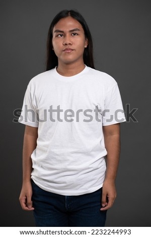 Portrait of one guy with long hair isolated on grey studio background