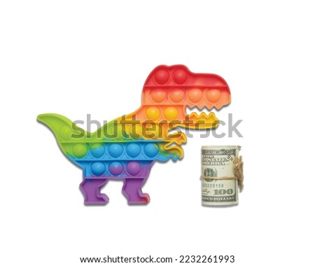 Flatlay picture of pop it colourful pop it dinasour with roll of fake money on white background
