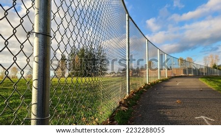 Empty road beside mesh fence in elementary school area, wide angle Royalty-Free Stock Photo #2232288055