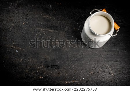 Fresh milk in a can on the table. On a black background. High quality photo Royalty-Free Stock Photo #2232295759