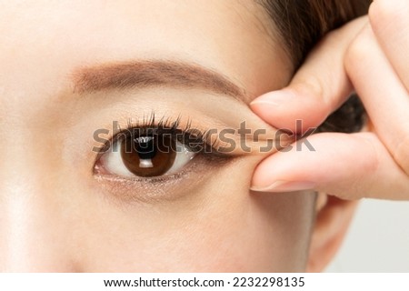 A woman is picking the corner of her eye. Royalty-Free Stock Photo #2232298135