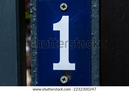 Number one 1, white on a blue metallic background