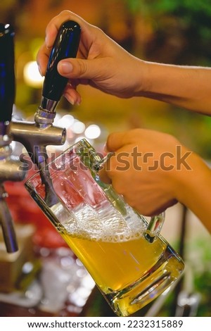 Picture of a craft beer being pressed from a beer dispenser. Try a craft beer in a pub to celebrate.