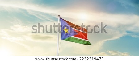 South Sudan national flag waving in beautiful sky.