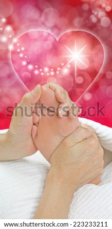 Foot Massage Christmas Gift Idea - Reflexologist holding female client's foot with both hands warming up middle section of foot with a love heart and Christmas red bokeh background