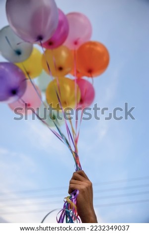Balloon Hand in Happy birthday party sky background with string and ribbon helium Ballon floating in celebrate wedding day.Concept of balloon in wedding and birthday party-Vertical image.