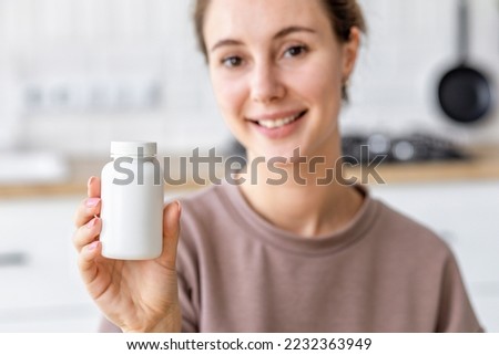 Happy young caucasian woman holding bottle of dietary supplements or vitamins in her hands. Close up. Healthy lifestyle concept Royalty-Free Stock Photo #2232363949