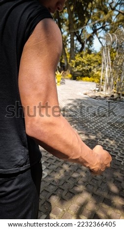 man showing big and dashing muscles outdoor. muscular and sinewy hand.