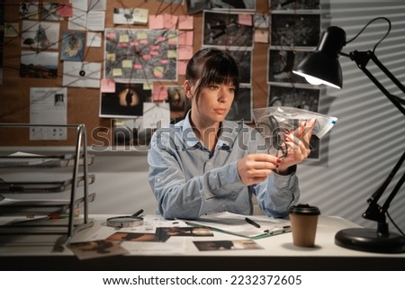 Detective working in her office with evidence. Copy space