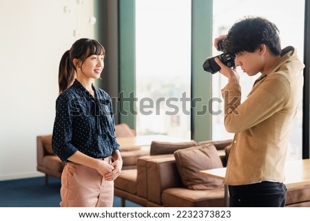 Male photographer taking portrait photos of a woman