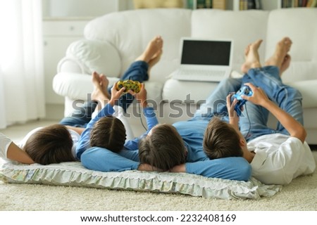 parents with children with laptops are lying on the back on the carpet