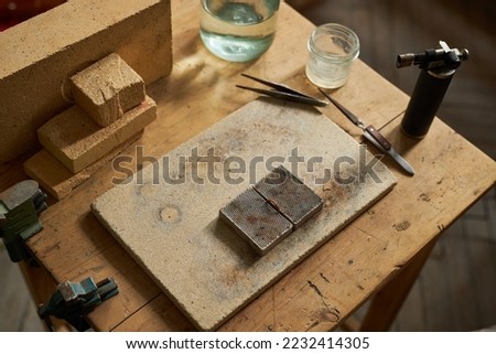 Top view background of rustic jewelers workstation with ring blank on wooden table and tools, copy space