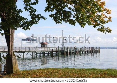 Jetty at the womans island. Tourist arrive at the Frauen insel in autumn to visit the Frauenwörth Abbey in Chiemsee. Sign translation: North Jetty, Departure in direction Gstadt, keep clear.
