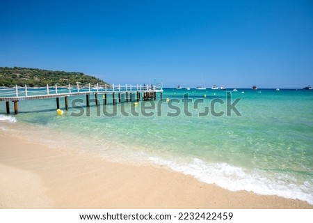 Wooden pier for guests of yachts on legendary Pampelonne beach near Saint-Tropez, summer vacation on white sandy beach of French Riviera, France Royalty-Free Stock Photo #2232422459