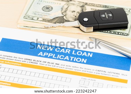 Car loan application with car key, pen, and dollar banknote
