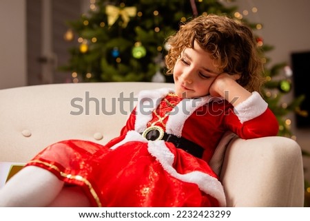 Adorable girl in Christmas dress near the classic decorated christmas tree