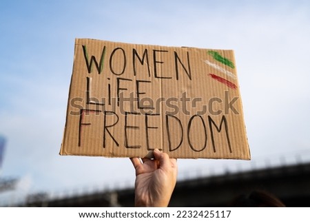 Demonstrator holding "Women, Life, Freedom" placard Royalty-Free Stock Photo #2232425117