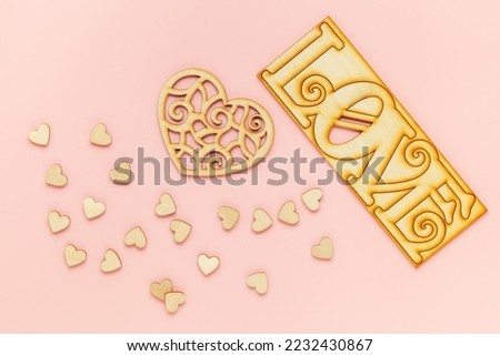 Wooden hearts on a pink background as a symbol of love. Valentine day concept. Top View