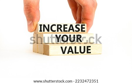 Increase your value symbol. Concept words Increase your value on wooden blocks on a beautiful white table white background. Businessman hand. Business increase your value concept. Copy space.