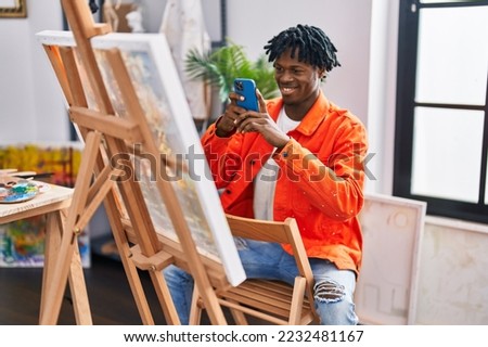 African american man artist smiling confident make picture by smartphone to draw at art studio