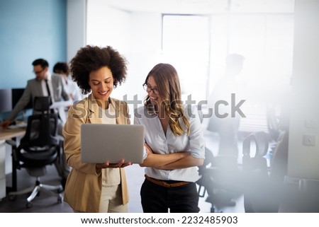 Happy multiethnic smiling business women working together in office Royalty-Free Stock Photo #2232485903