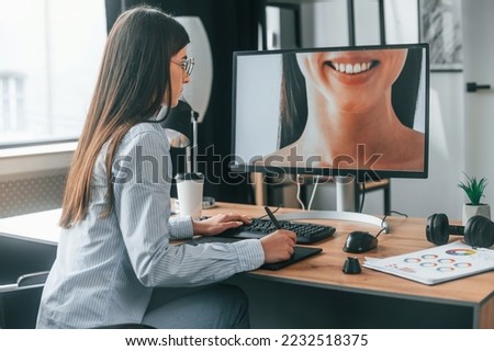 Portrait of woman. Young female retoucher working with computer and graphic tablet.
