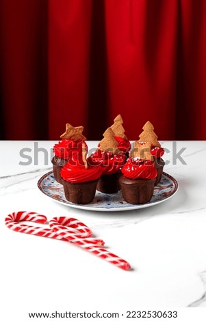 christmas cupcakes on plate with red cream on white table
