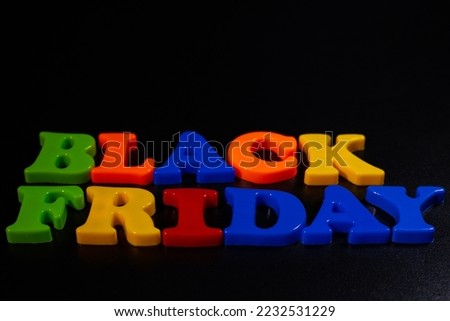 Plastic letters are placed on a black background and the word Black Friday is written. Discounts.