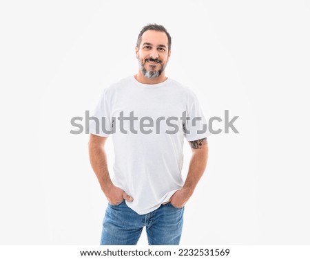A portrait of a bearded middle-aged man looking thoughtfully at the camera over a white studio background