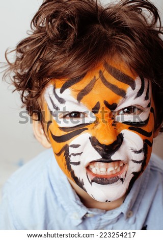 little cute boy with faceart on birthday party close up, little cute orange tiger